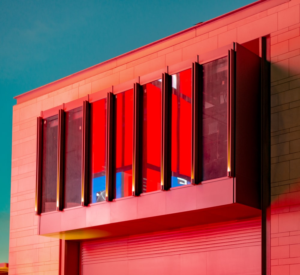 a red building with red shutters and a blue sky in the background