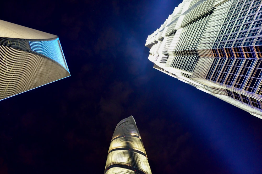 looking up at tall buildings in a city at night