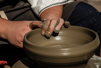 a man is making a bowl on a potter's wheel
