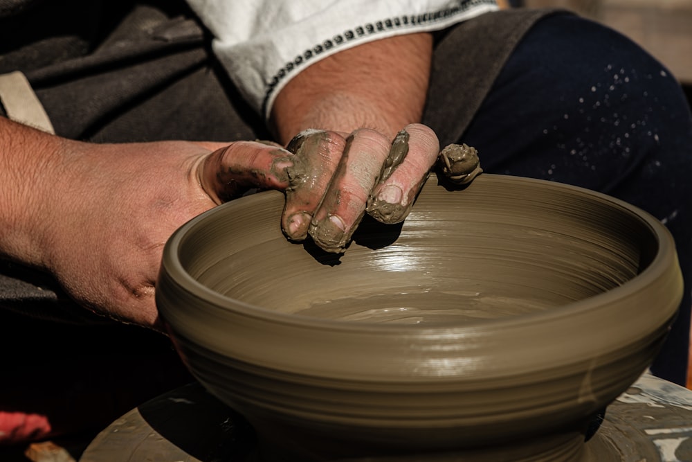 a man is making a bowl on a potter's wheel