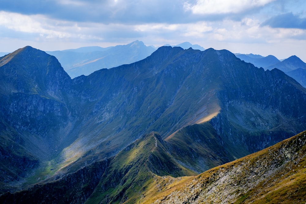 a view of a mountain range from the top of a hill