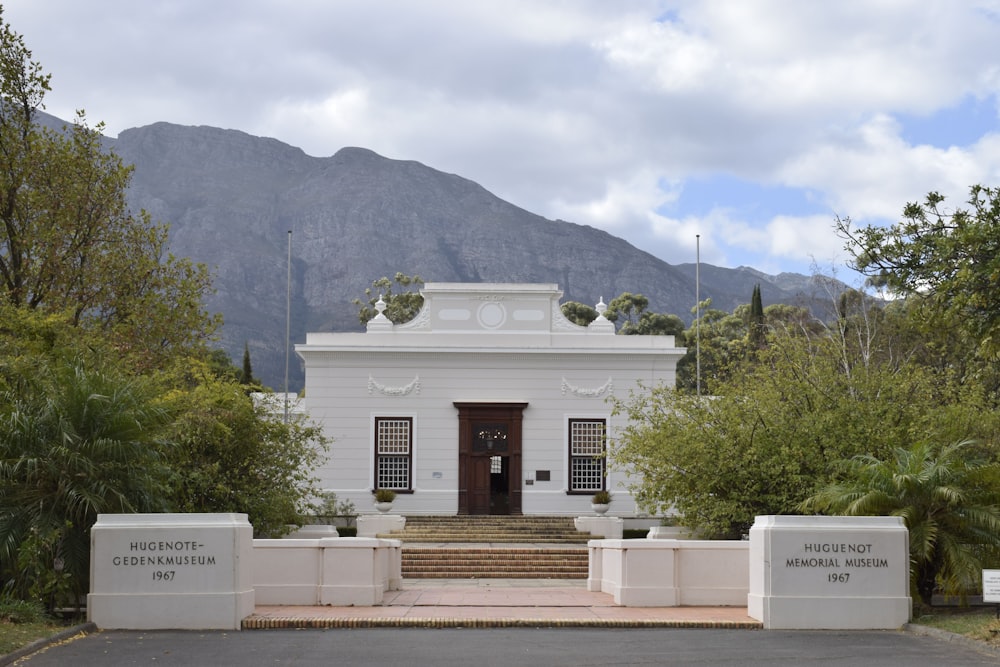 a white building with a mountain in the background