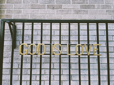 a sign that says god is love on a fence