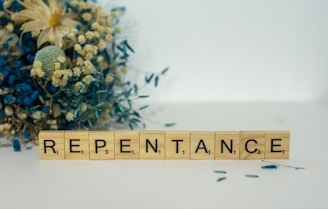 a wooden block that says repentance next to a bouquet of flowers