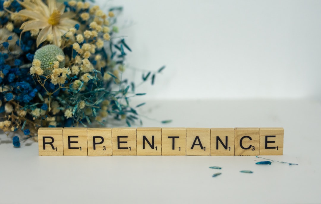a wooden block that says repentance next to a bouquet of flowers