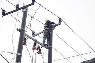 Electrician working carefully on residential wiring with tools and safety gear.