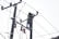 A person wearing a safety harness and helmet is working high on an electrical pole surrounded by wires.