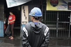 a man wearing a hard hat standing in the rain