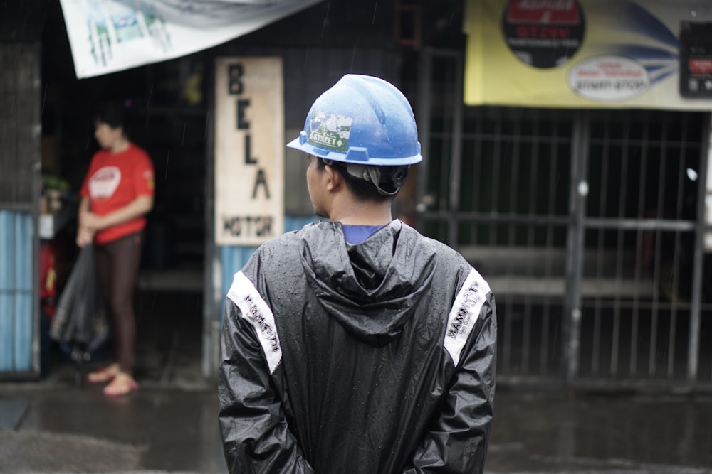 a man wearing a hard hat standing in the rain
