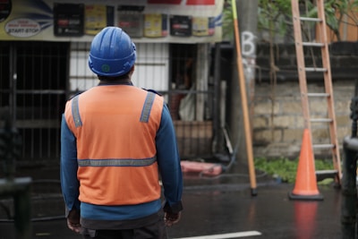 a man in an orange vest and a blue helmet