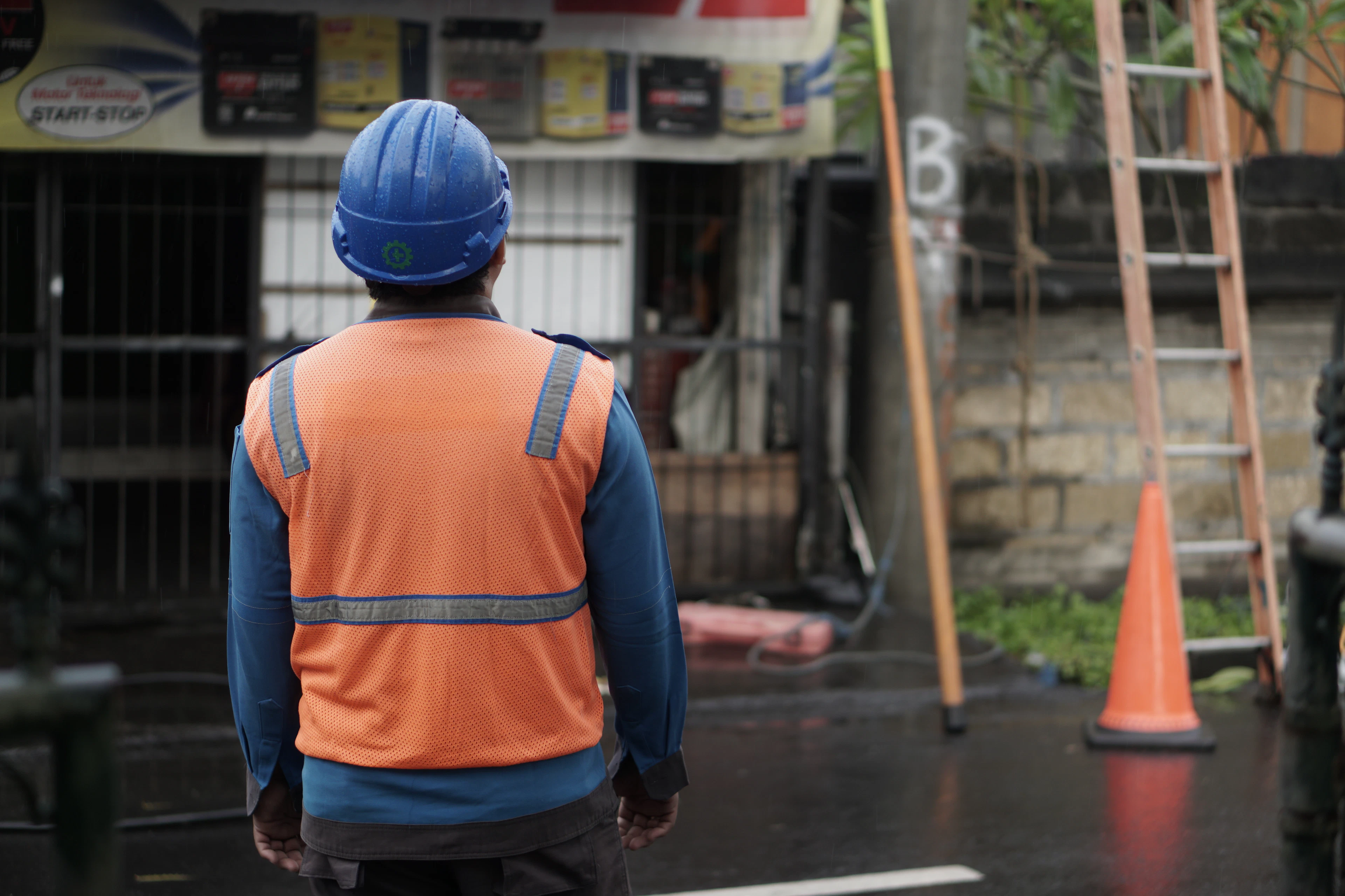 A worker in a high-visibility vest and hard hat at a work site