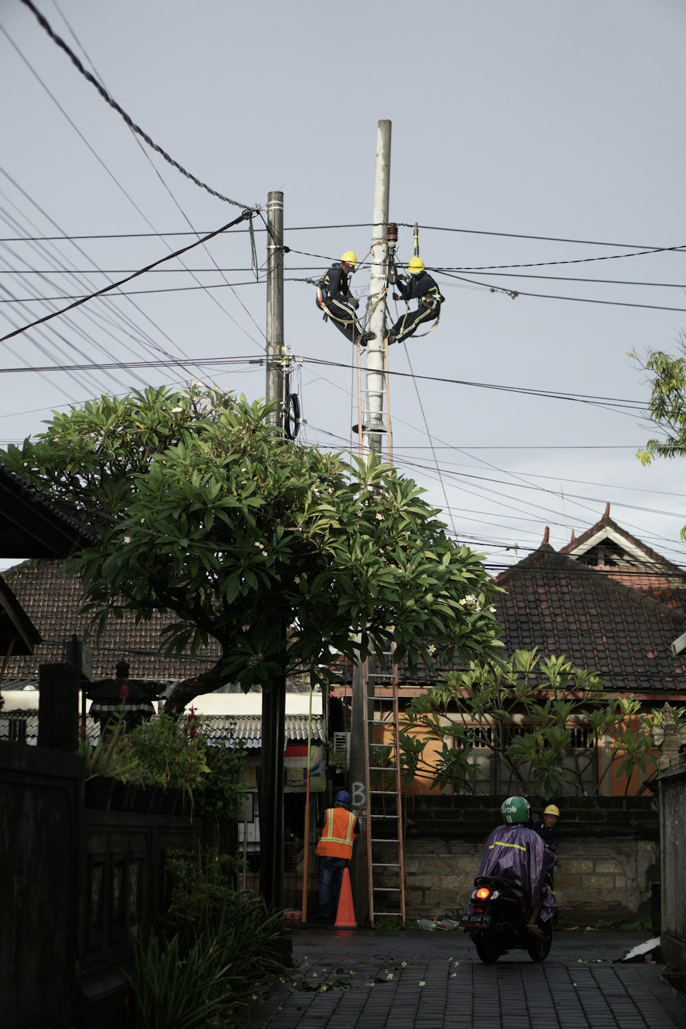 a man riding a motorcycle down a street next to power lines