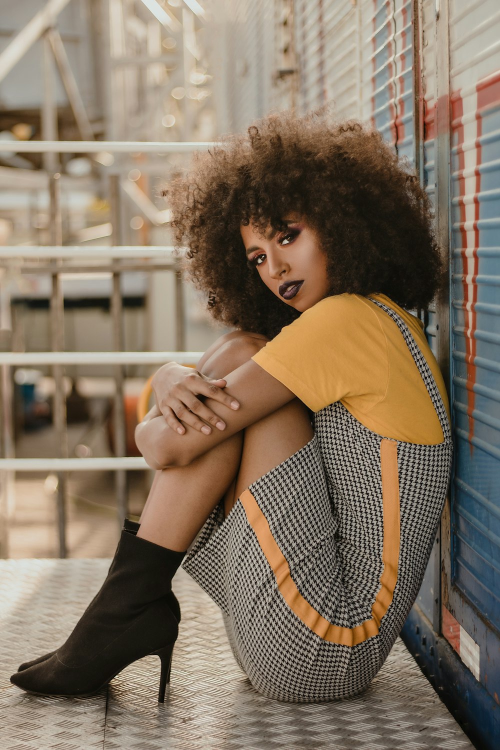 a woman sitting on the ground with her legs crossed