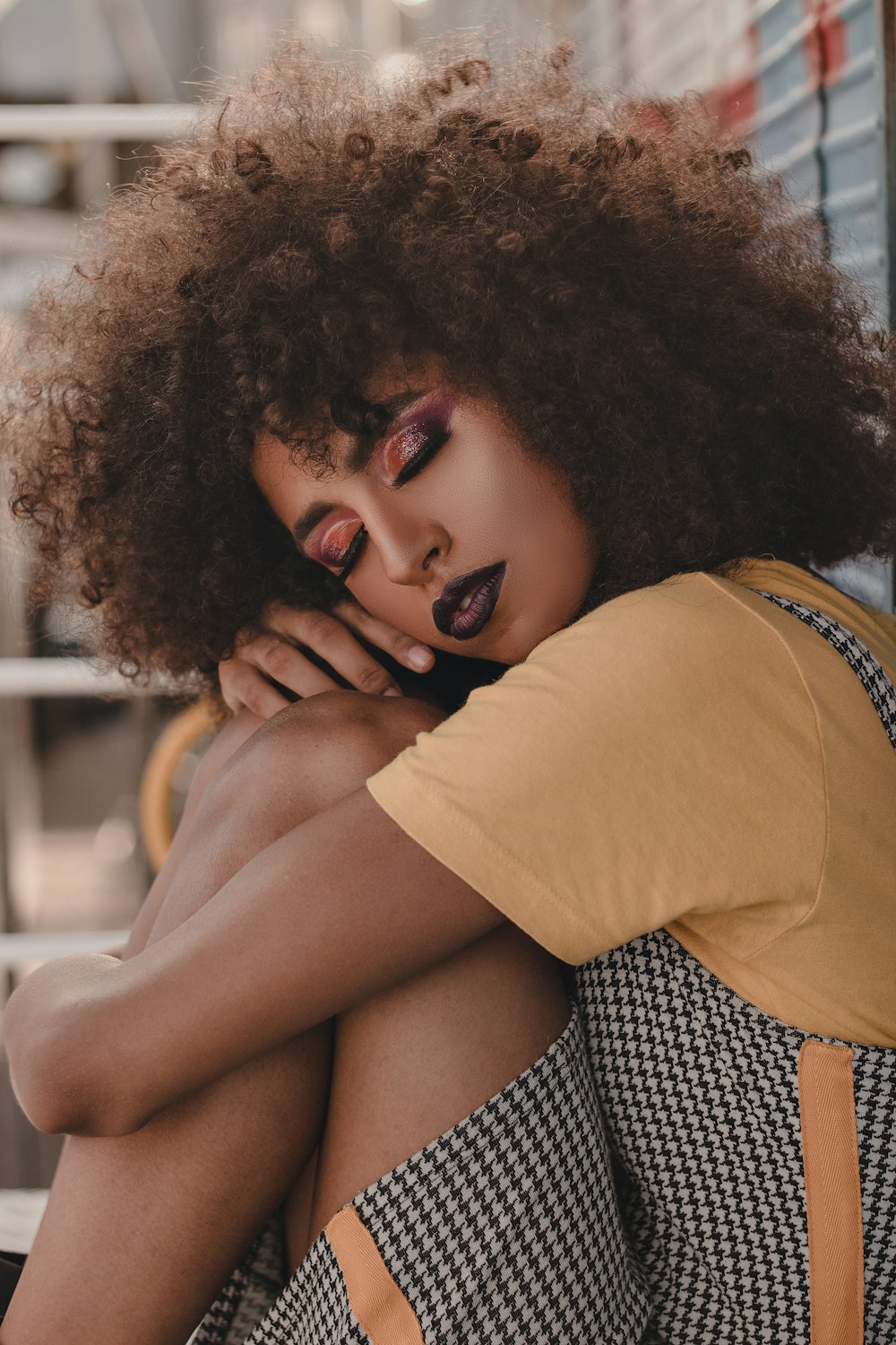 a woman sitting on a bench with her hands on her face