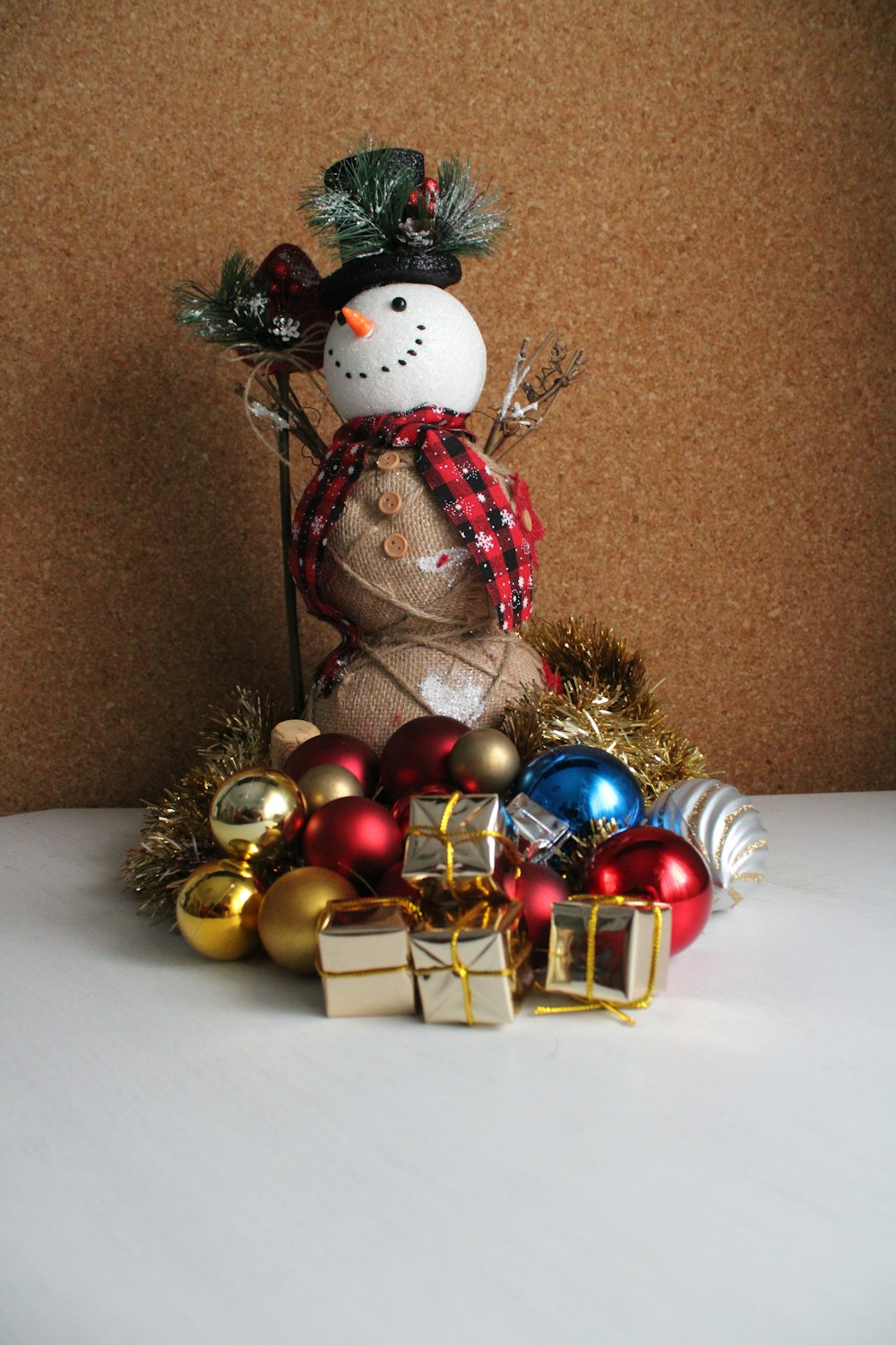 a snowman is surrounded by christmas ornaments