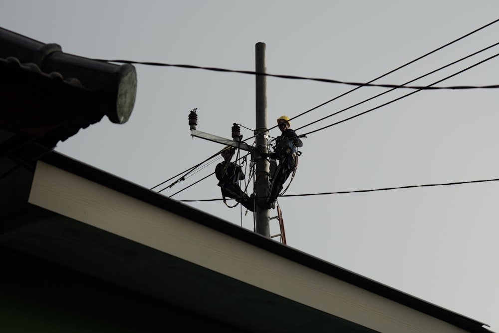 Eine Stromleitung mit einem Mann auf einer Leiter, der daran arbeitet