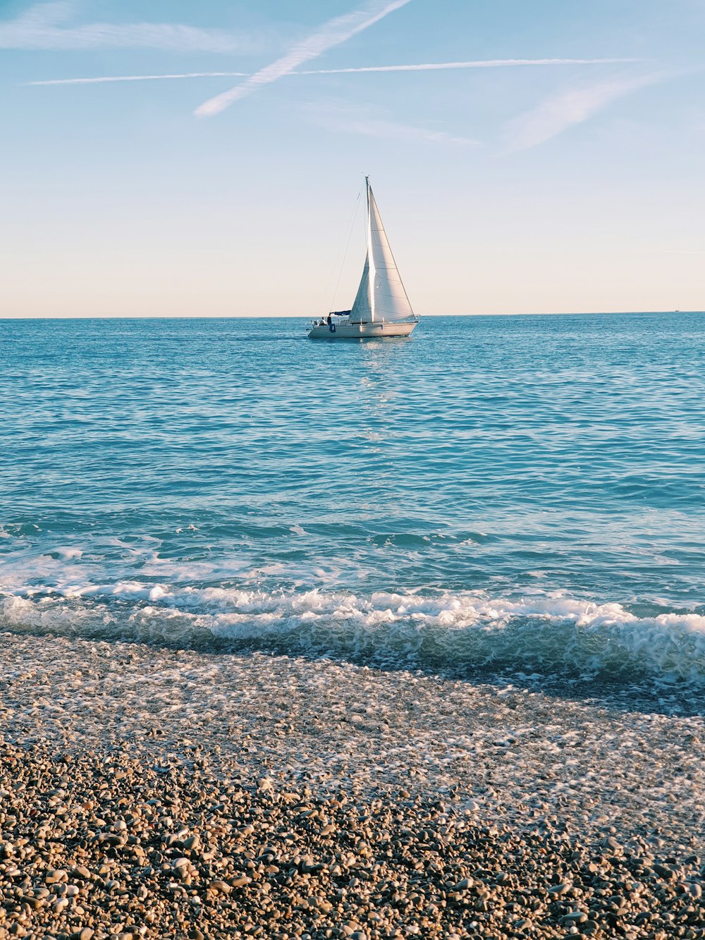a sailboat in the ocean on a sunny day