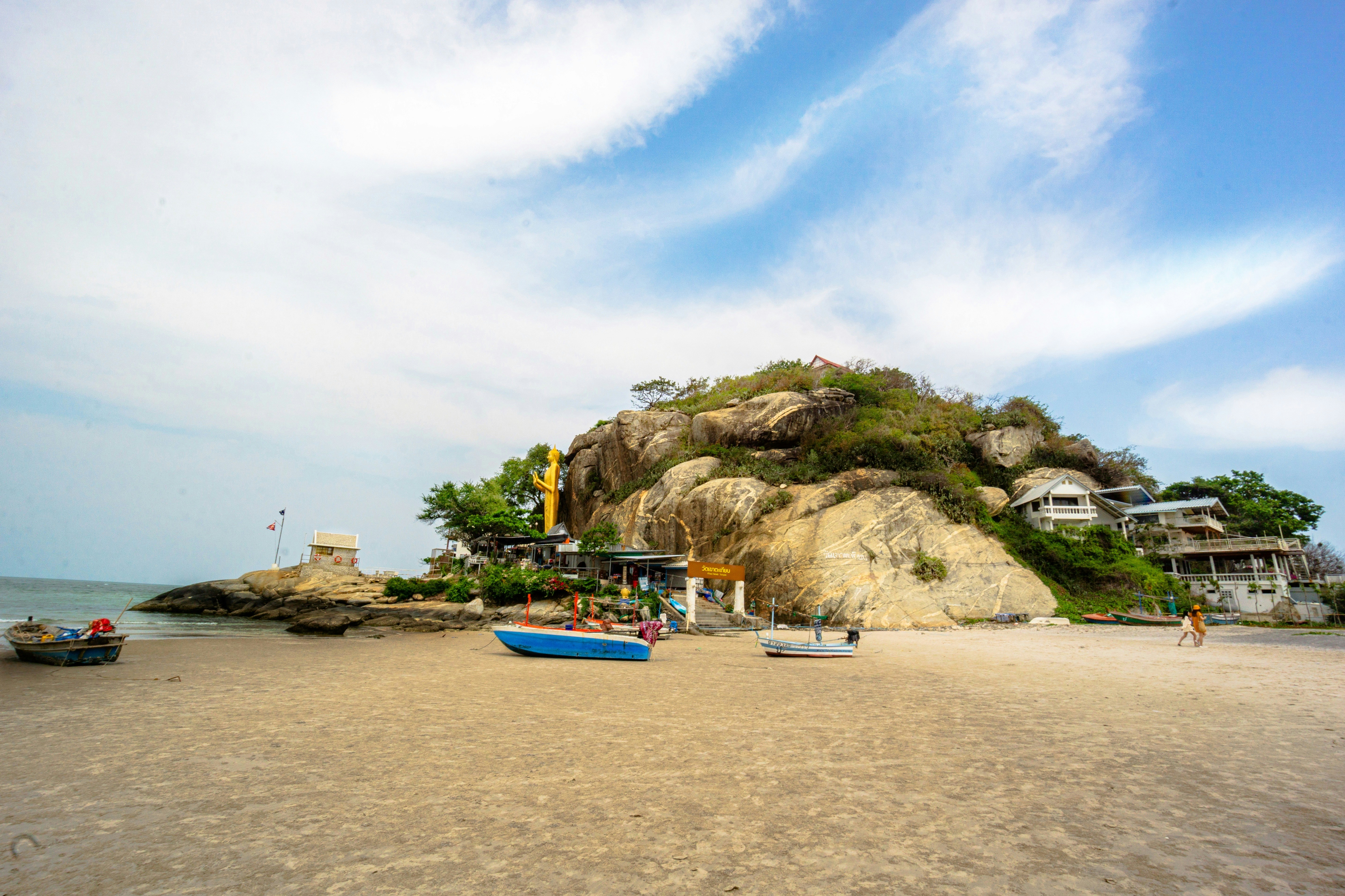 a sandy beach with boats on it under a blue sky