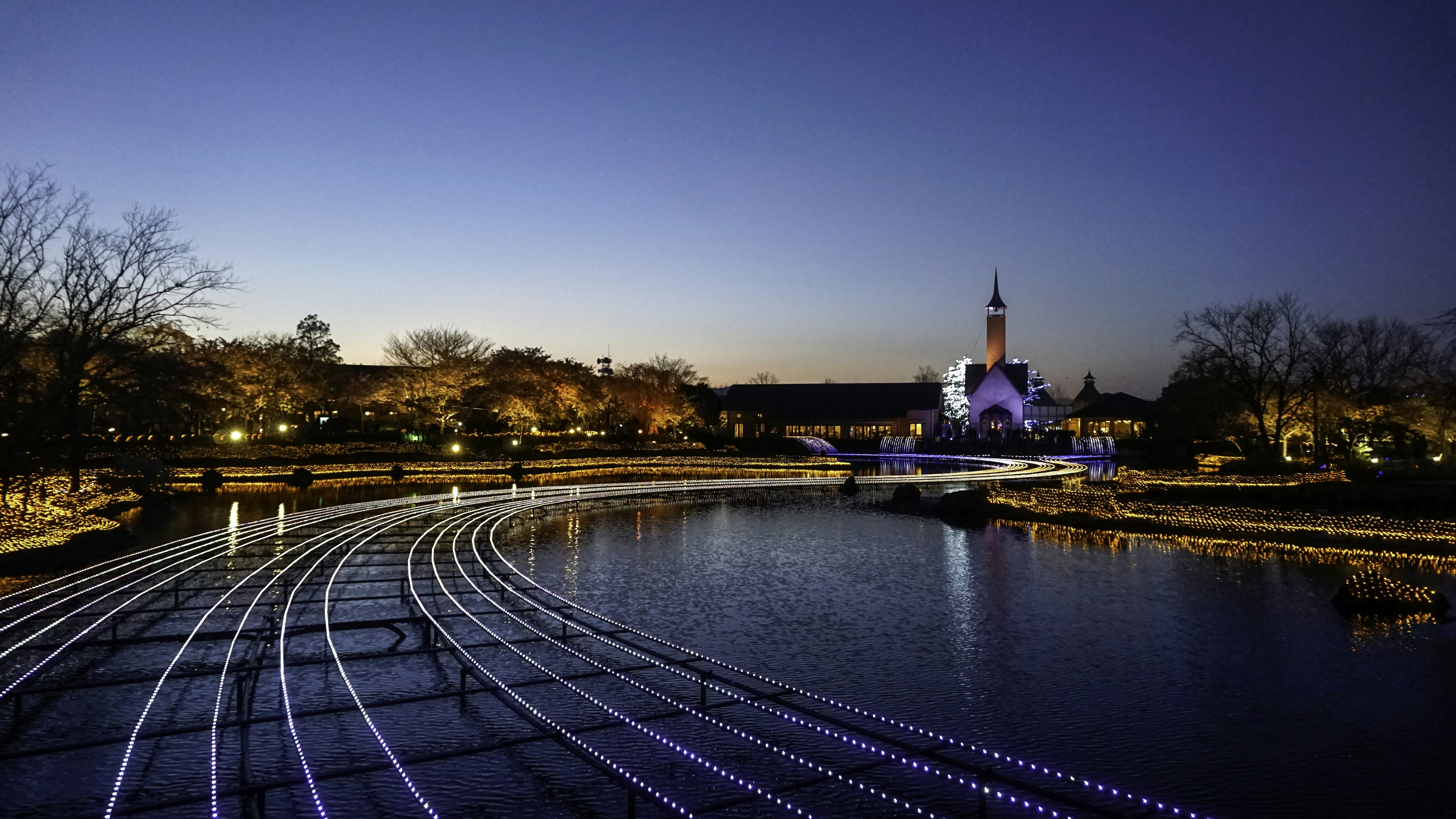 a train track running across a river at night