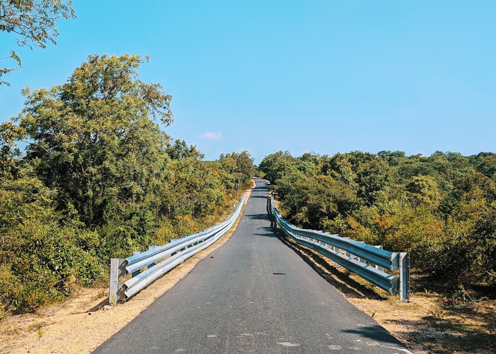 uma estrada que tem uma cerca azul ao lado dela