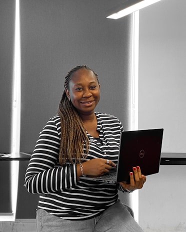 A friendly person using a laptop at home, looking relieved after completing a form.