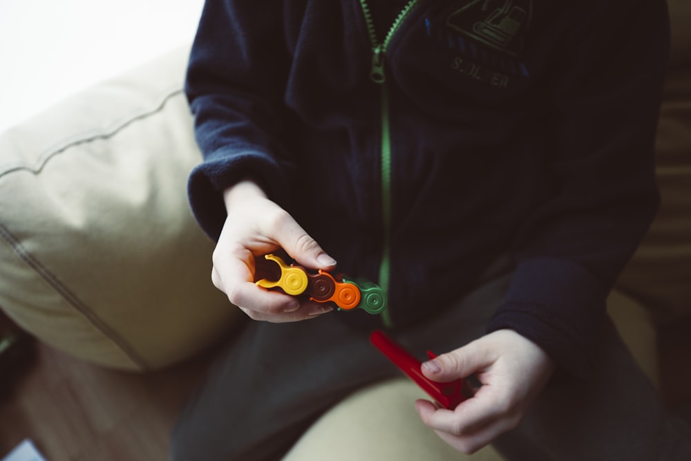 a person sitting on a couch holding a pair of scissors