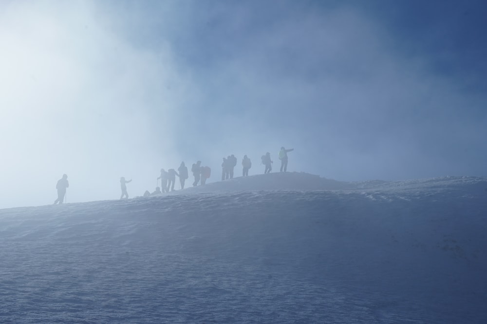 a group of people standing on top of a snow covered slope