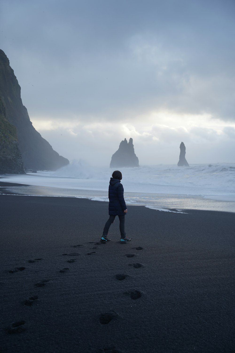 a person standing on a beach next to the ocean