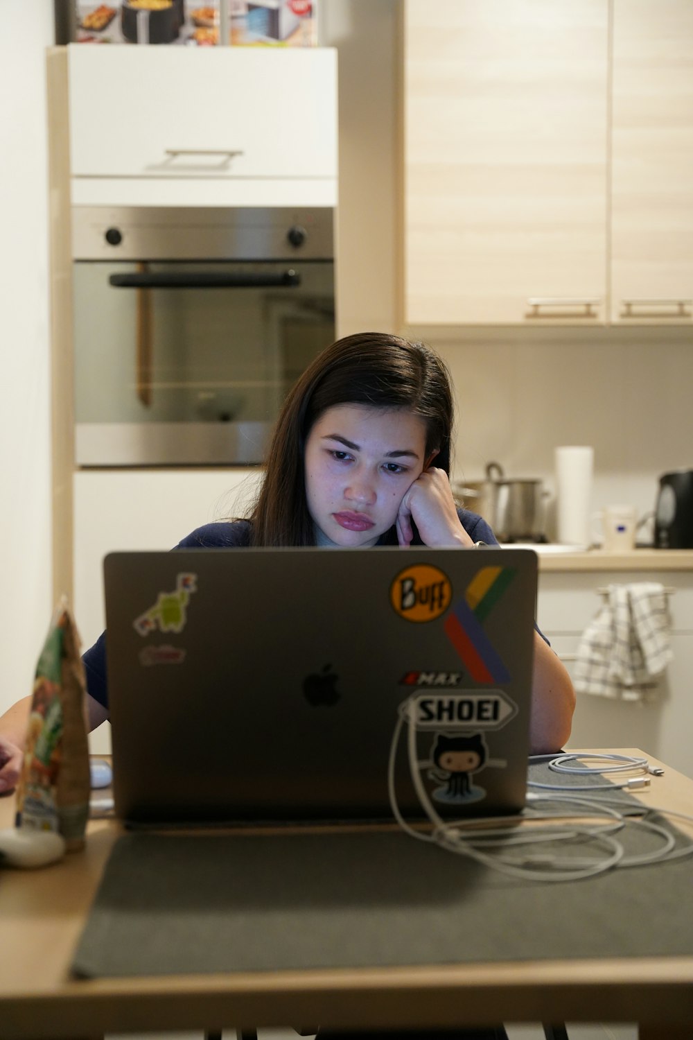 a woman sitting in front of a laptop computer