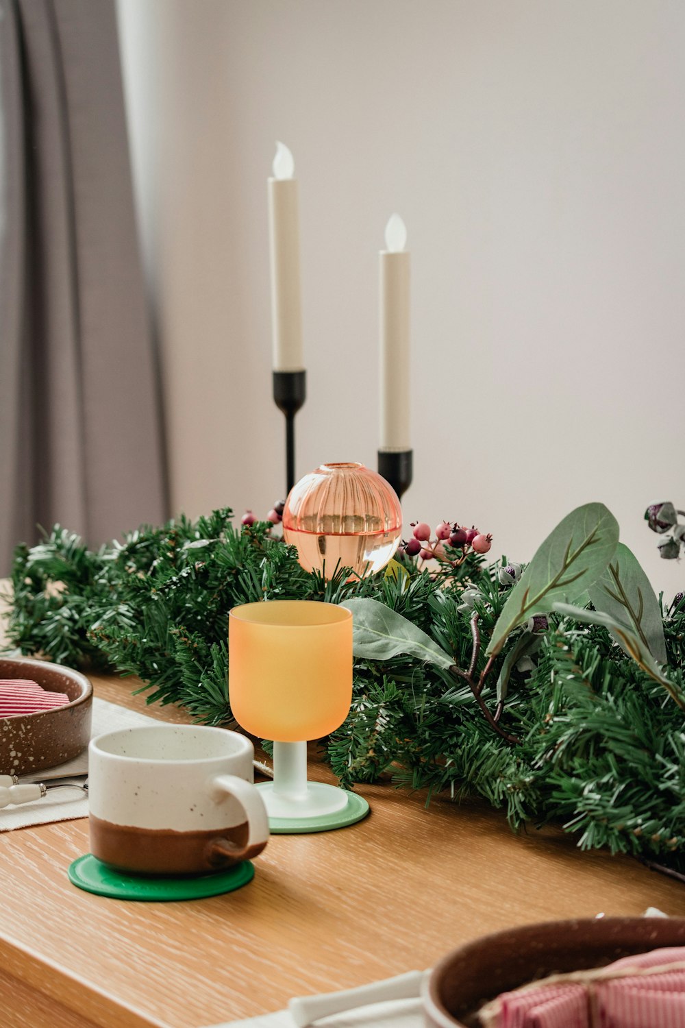 a wooden table topped with candles and dishes