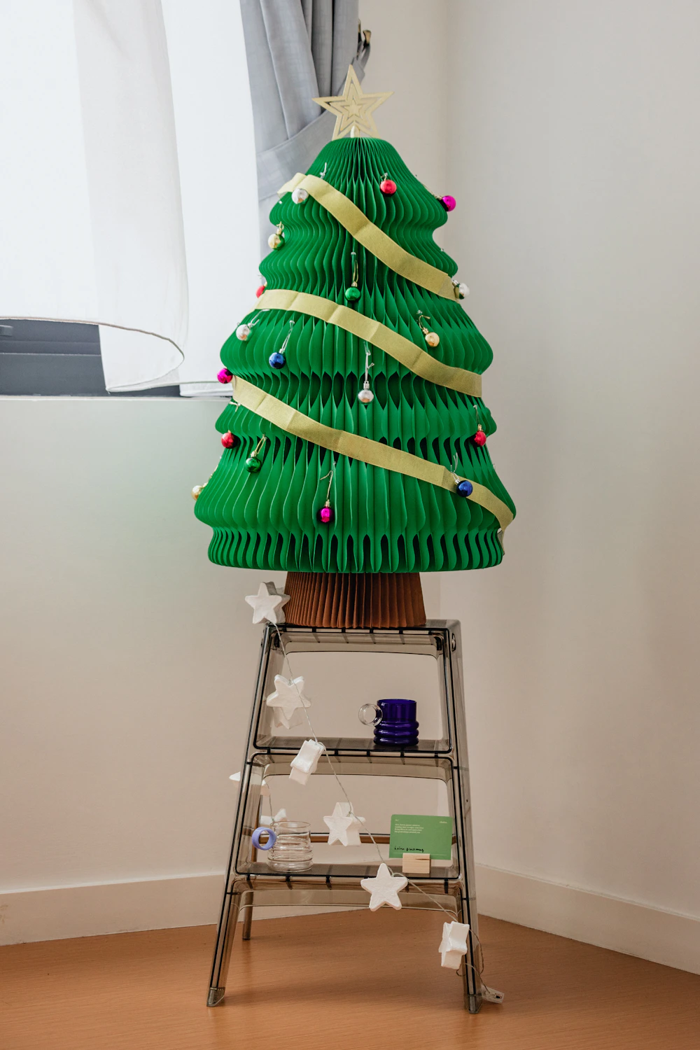 A handmade Christmas tree folded from green paper · illustrative photograph