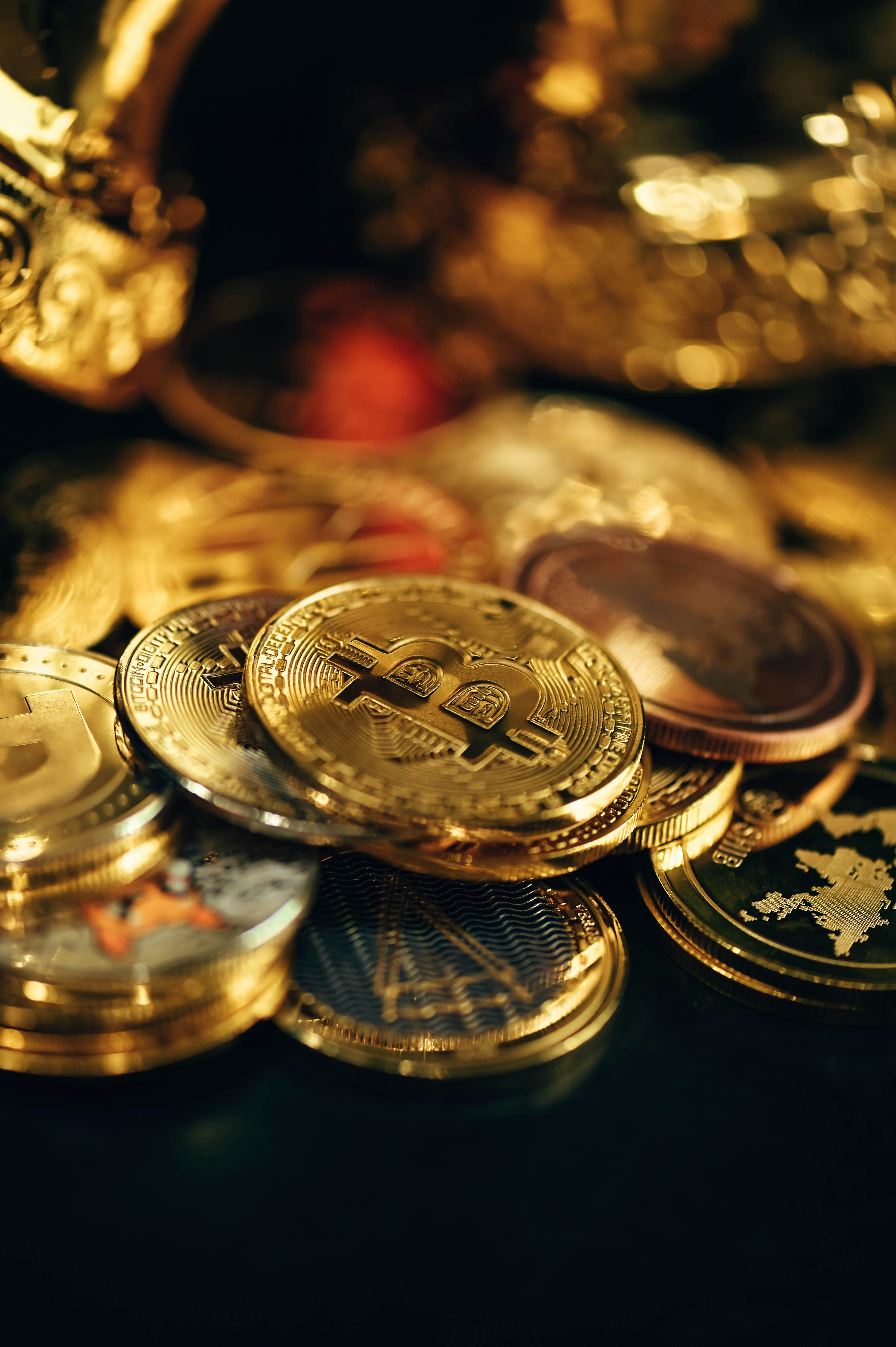 A pile of gold cryptocurrency coins in the dark