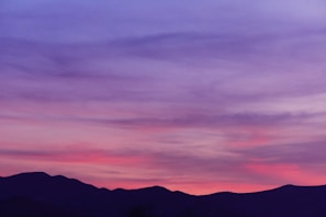 A serene landscape with a vibrant sunset over mountains.