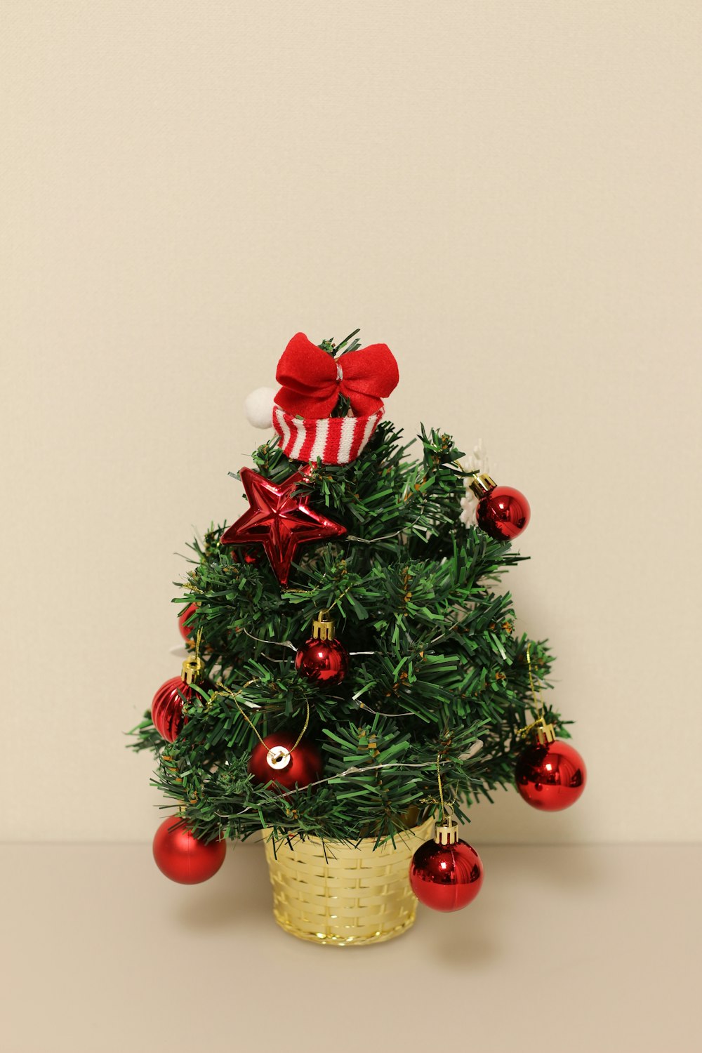 ein kleiner Weihnachtsbaum mit Ornamenten in einem Korb