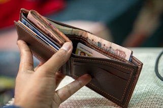 a person holding a wallet with money in it