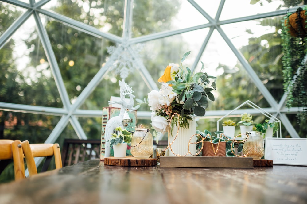 a wooden table topped with vases filled with flowers