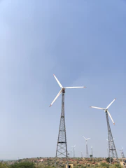 A sleek digital twin simulation of a wind farm with highlighted turbine adjustments in cyan glow.