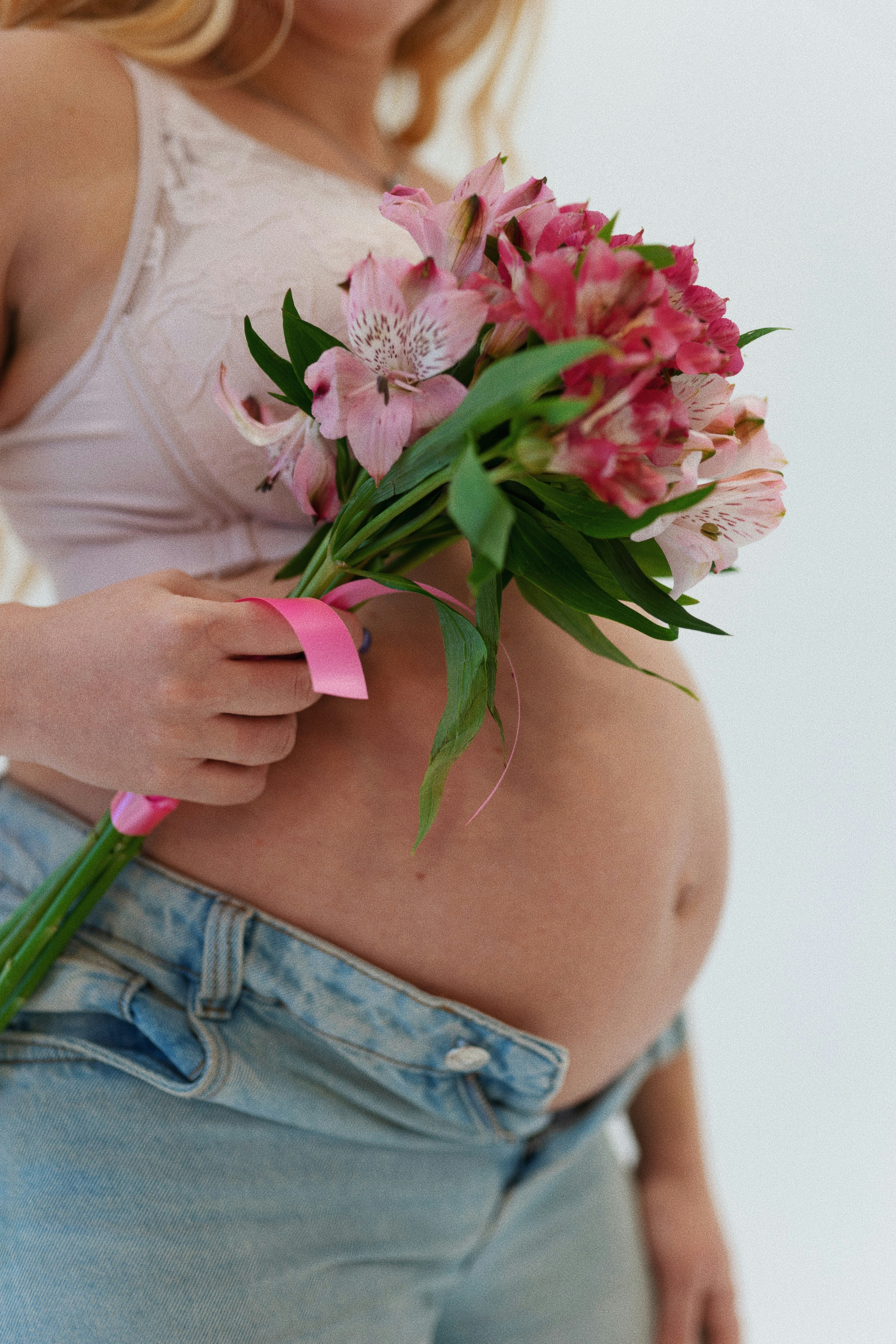 a pregnant woman holding a bouquet of flowers