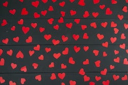 a bunch of red hearts on a black background
