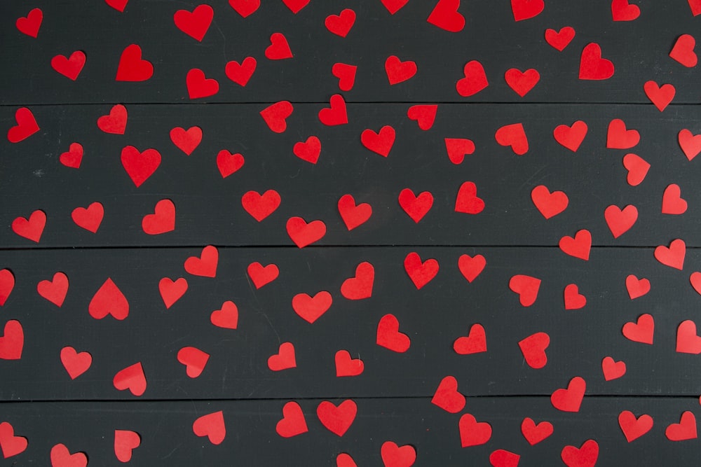 a bunch of red hearts on a black background