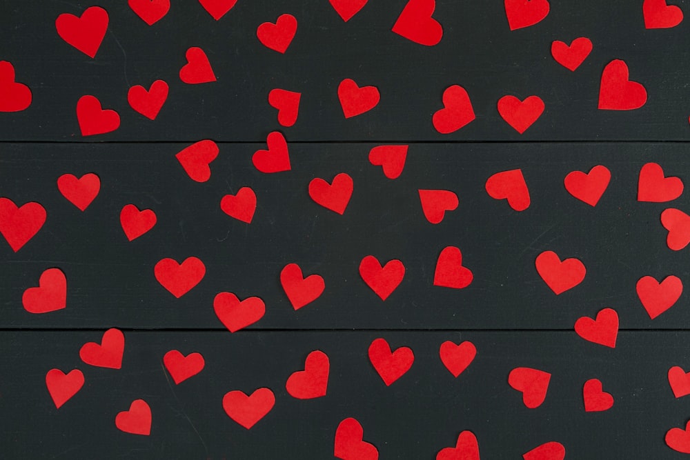 a bunch of red hearts on a black background