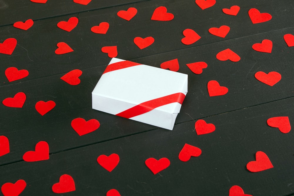 a white box with red hearts on a black surface