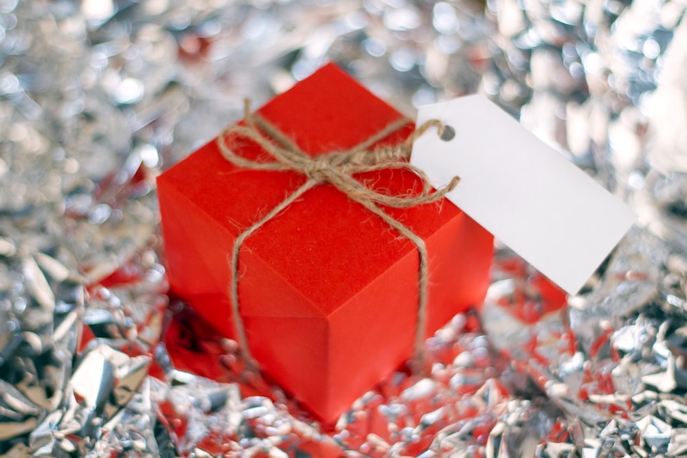 a red gift box with a white tag on it