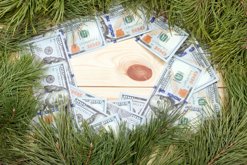 a bunch of money sitting on top of a wooden table