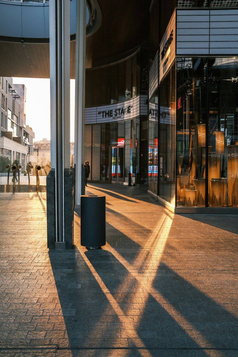 a sidewalk with a trash can on the side of it