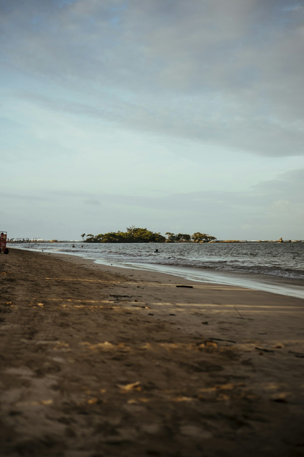 a truck is parked on the beach near the water