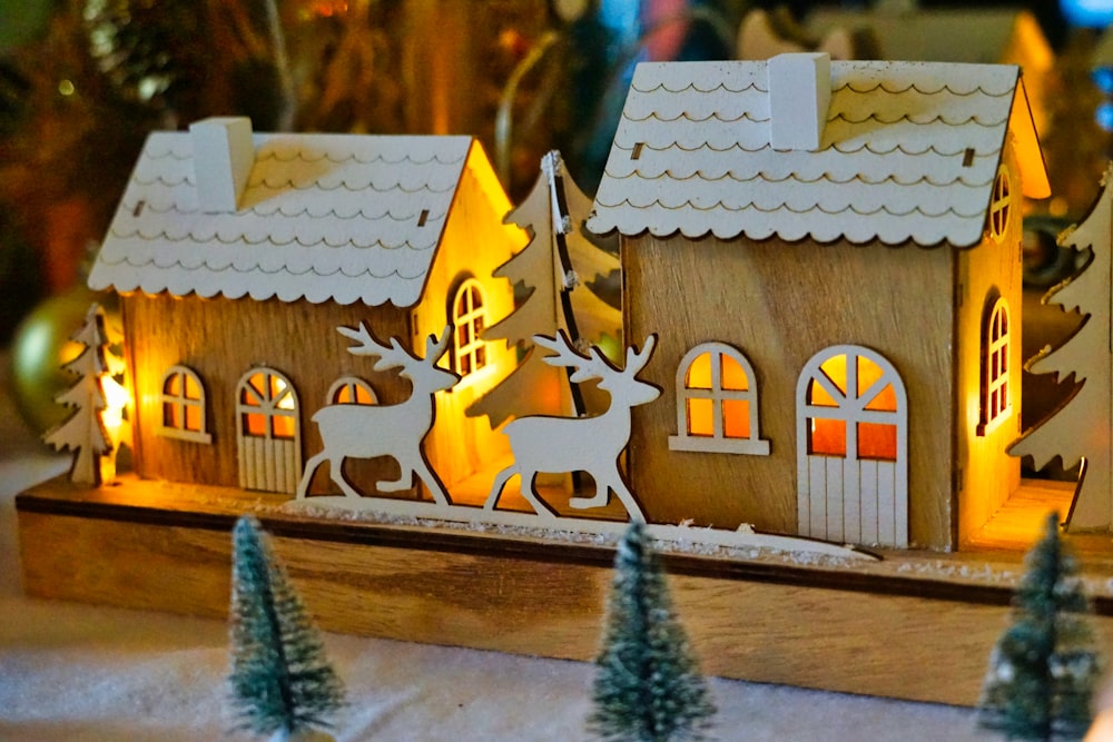 a wooden house with a deer and a sleigh on top of it