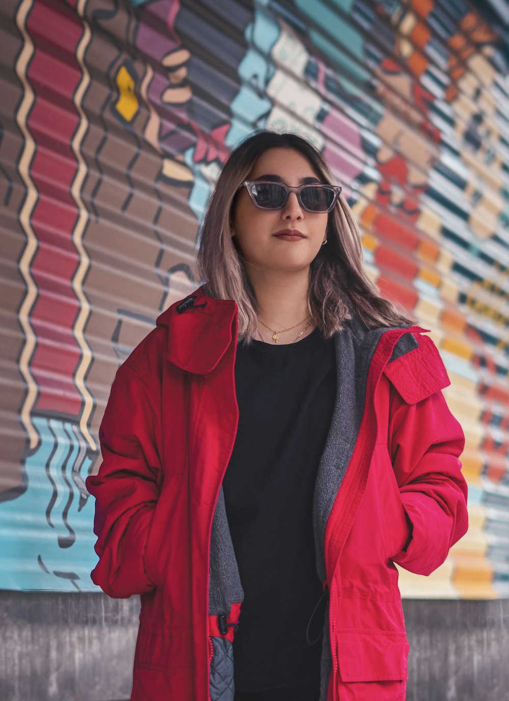 a woman standing in front of a colorful wall