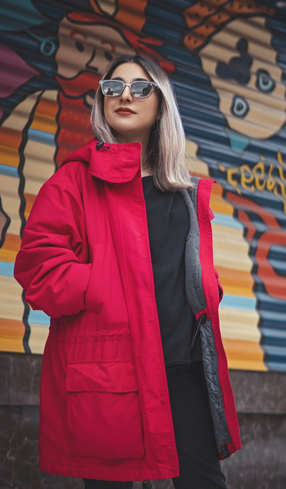 a woman standing in front of a colorful wall