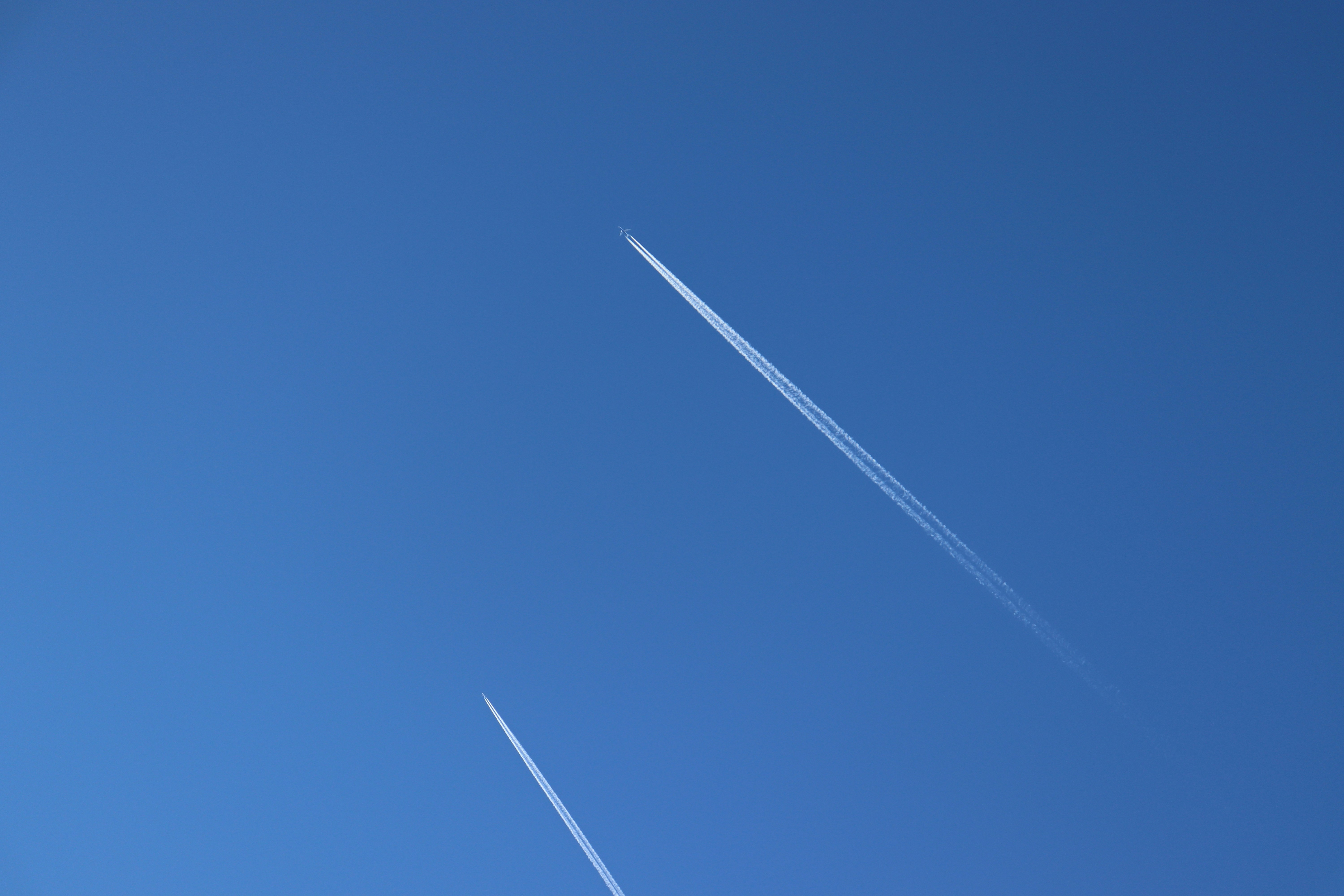 an airplane is flying in the blue sky, 
